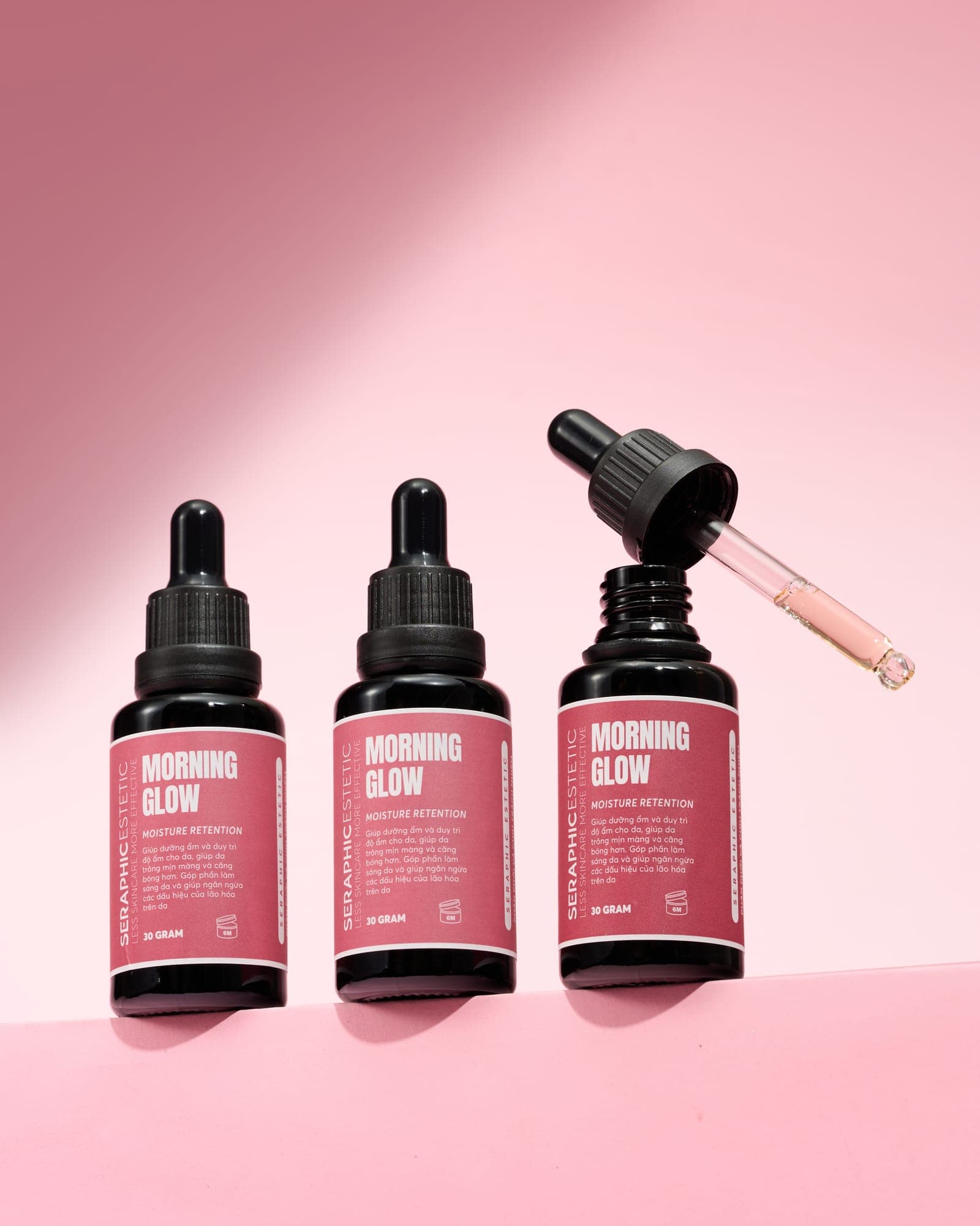 Ba chai serum Morning Glow trên nền hồng